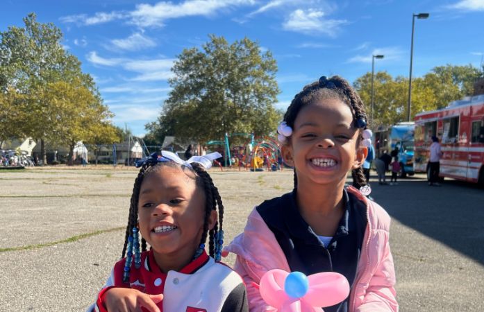 two girls smiling at a carnival 